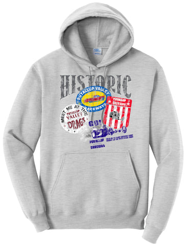 A light gray hoodie with a printed design on the front. The design features the word "HISTORIC" prominently at the top with colorful, vintage-inspired graphics below. There are references to "Puyallup Valley Raceway" with imagery of racing cars, flags, and typography indicating nostalgia for the drag racing events. The hoodie has a standard pouch pocket in the front and the brand tag "Port & Company" is visible near the collar.